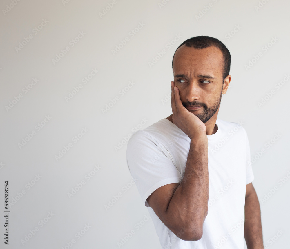 Young african american man wearing white t-shirt touching mouth with hand with painful expression because of toothache or dental illness on teeth. Young african american man wearing white t-shirt touching mouth with hand with painful expression because of toothache or dental illness on teeth.