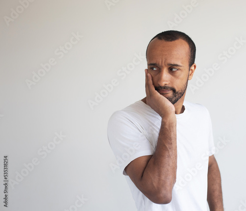 Young african american man wearing white t-shirt touching mouth with hand with painful expression because of toothache or dental illness on teeth.