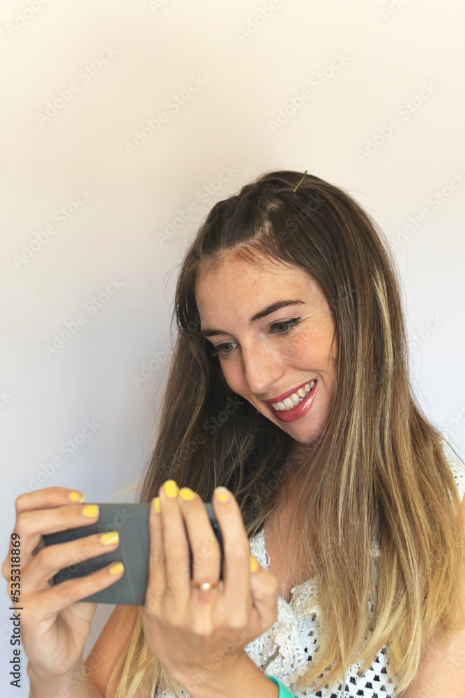 Happy young girl looking at her mobile phone Happy young girl looking at her mobile phone