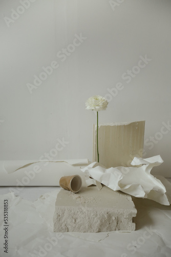 beautiful still life of a flower, concrete and paper