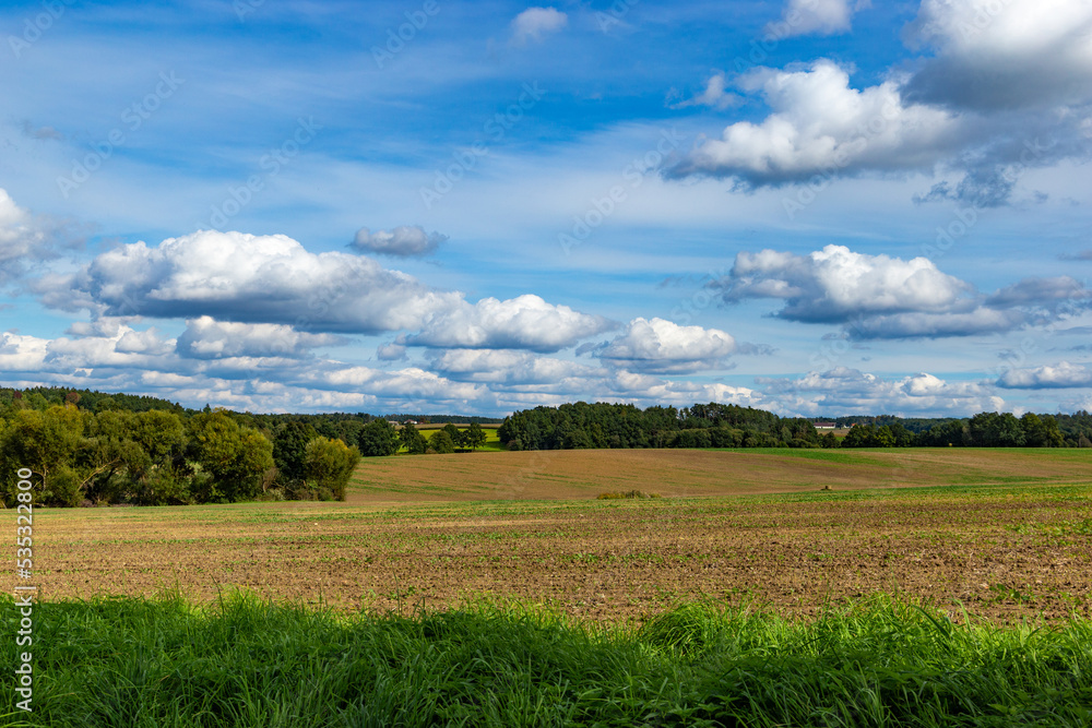 Fields and blue sky with clouds. Autumn landscape.