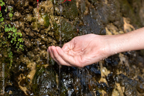 To collect fresh water from a natural spring, springs, mountain waterfall in your hand