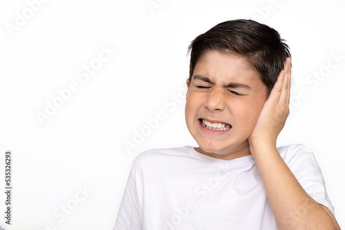 Sad little kid with earache on a white background. Ear ache concept. photo