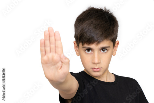 Little caucasian kid standing with outstretched hand showing stop sign, preventing you. Isolated on the white background