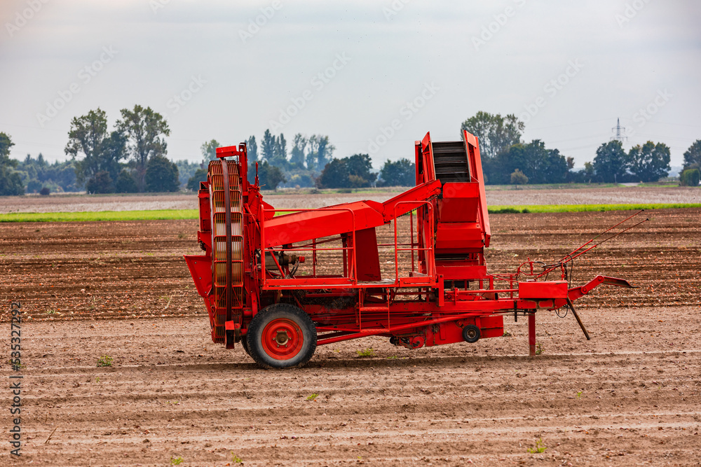 Fototapeta premium A red onion harvester in a field