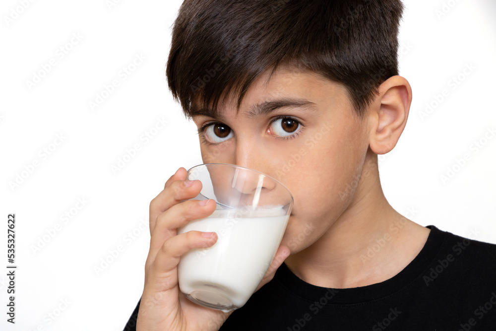 Photo of adorable young happy boy looking at camera.Cute kid drinking milk on white background Photo of adorable young happy boy looking at camera.Cute kid drinking milk on white background