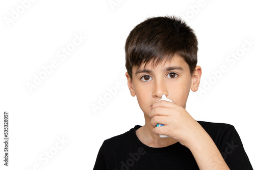 Little boy spraying medicine in nose, nose drops. Little child using nasal spray. Runny nose, cold, flu, illness, virus. Close up. Isolated on the white background