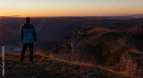 Homme au dessus de la falaise de Mouthier Haute Pierre dans le Doubs le soir avec la lumi  re d un coucher de soleil 