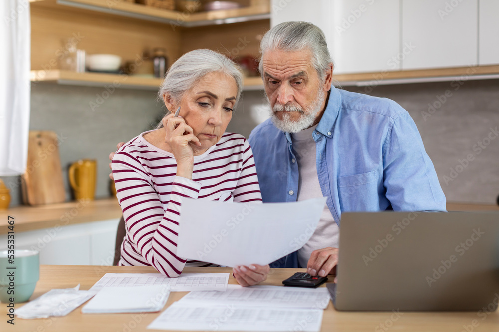 Upset Elderly Couple Checking Financial Documents While Calculating Family Budget At Home Upset Elderly Couple Checking Financial Documents While Calculating Family Budget At Home