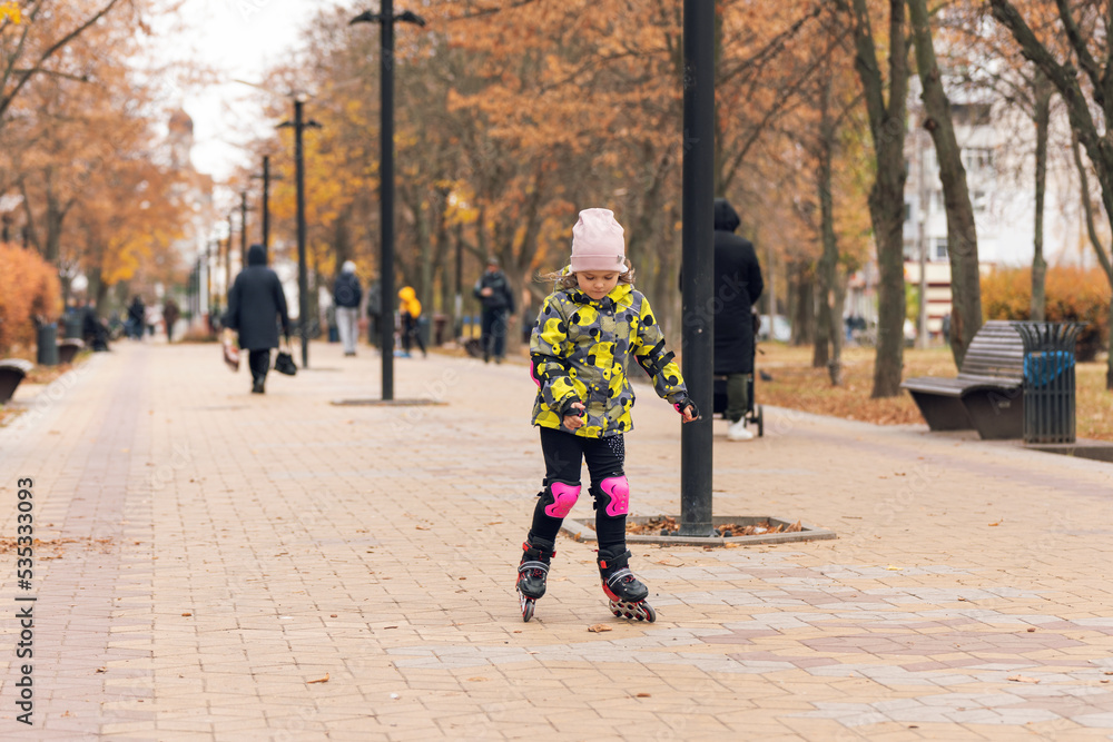 Obraz premium Cute little girl learning to roller skate