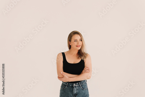 Portrait of a happy confident adult blonde business woman with positive emotions in a casual black T-shirt smiling and looking at the camera on a white isolated background. Space for text.