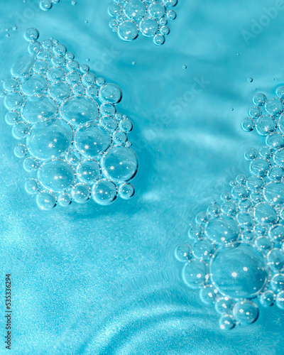 Cosmetic texture. Gorgeous structure of cosmetic gel bubbles on turquoise background. Macro photography with selective focus