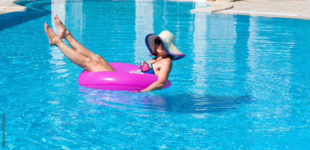Woman with slender legs in the pool on an inflatable circle