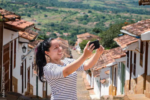 Young woman doing tourism in old town of Colombia, woman making selfie in colonial town, Barichara photo