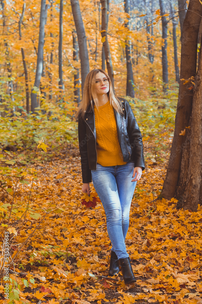 Girl holds fallen leaves and walks in autumn park. Seasonal concept. Girl holds fallen leaves and walks in autumn park. Seasonal concept.