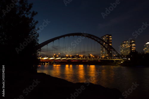 Night city lights - harbor bridge, river, water reflection and evening sky