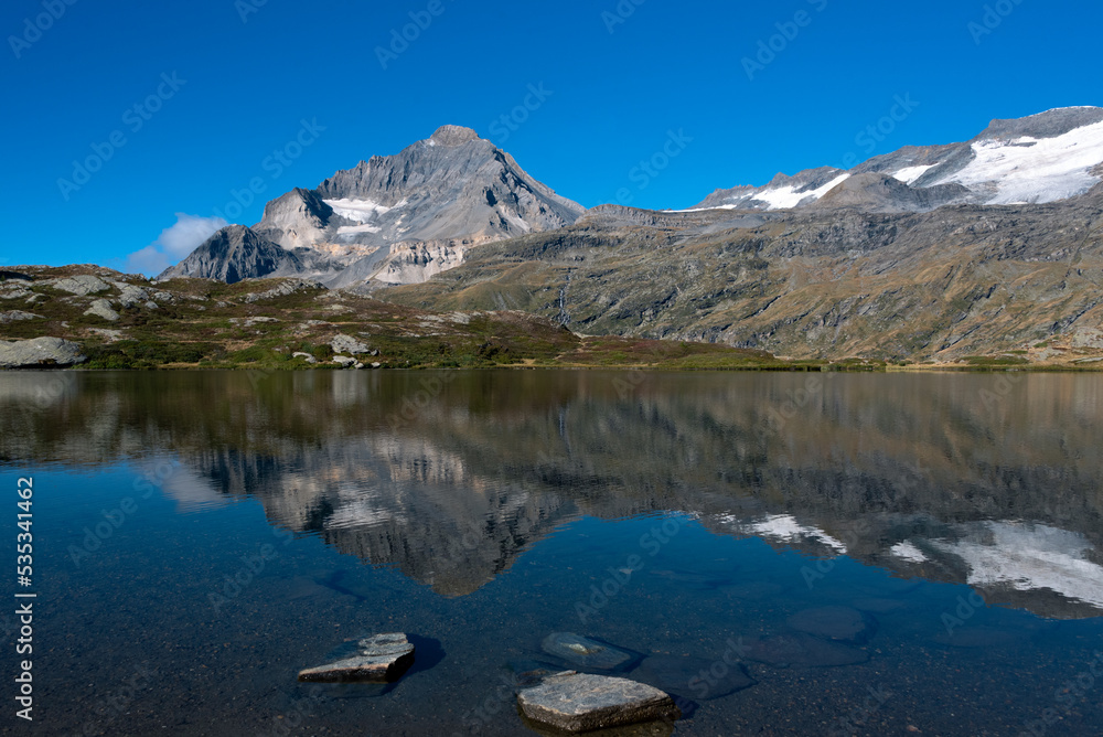 The majestic summit of the Dent Parrachee reflected in the waters of Lake Blanc in the French Alps in the Vanoise National Park