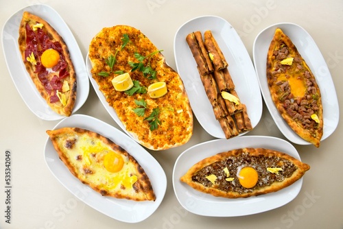 Traditional Turkish cuisine. Pizza, pita, pidesi, sucuk, hummus, kebab. Many dishes on the table. Serving dishes in restaurant. Background image. Top view, flat lay