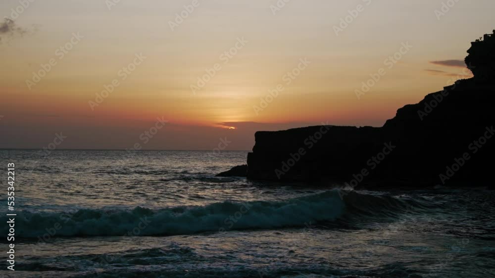 A sunset by the sea with waters and rocks by the coast and red sky A sunset by the sea with waters and rocks by the coast and red sky