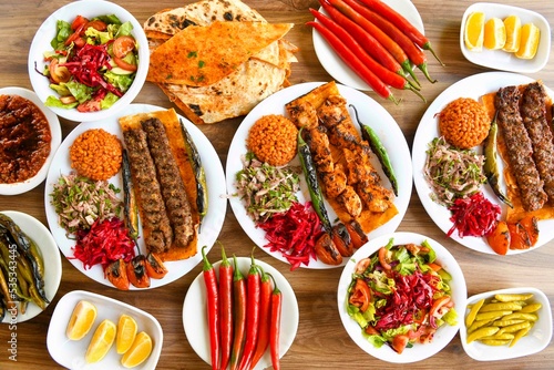 Delicious meat kebab with fresh vegetable salad served with variety of Turkish dishes and appetizers. Top view of assorted Turkish food and meze, tasty and healthy Mediterranean cuisine.