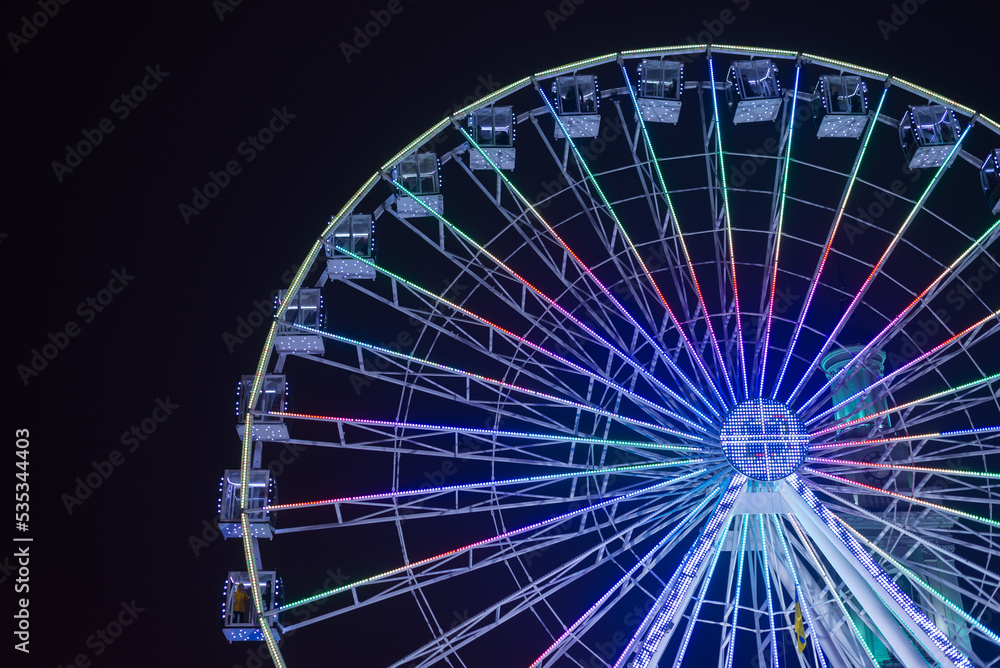 Ferris wheel in the City center. Winter seasonal night city background.