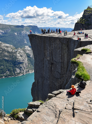 Tourists visiting the top of Preikestolen or "The Pulpit Rock" , a popular steep cliff above the Lysefjorden and one of the main tourist attraction in Norway.