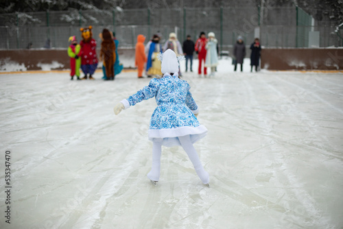 Child on skates. Ice rink in winter. Active lifestyle in winter. Girl is engaged in figure skating.