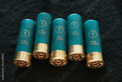 Shotgun shells on a black surface. Ammunition for 12 gauge smoothbore weapons. Hunting ammunition. Dark background.