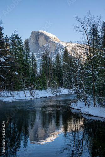 Half Dome with river in winter, Yosemite National Park, landscape with mountains, snow and trees
