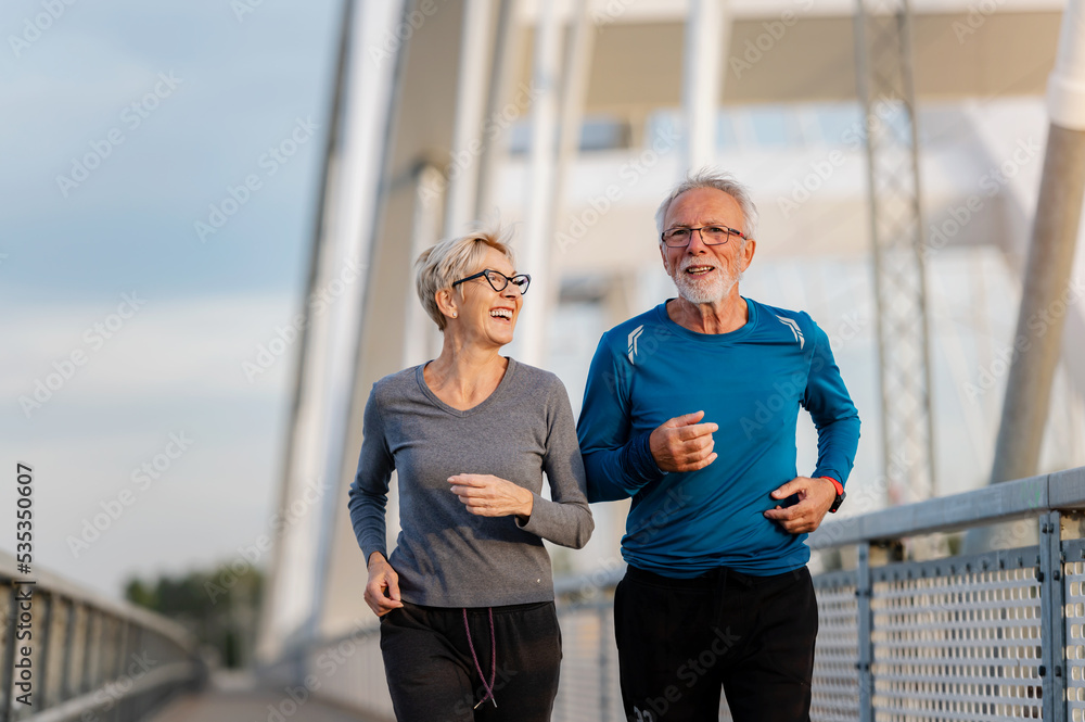 Ταπετσαρία Cheerful active senior couple jogging together outdoors on the bridge