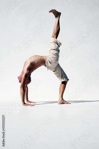 Fototapeta Naklejka Na Ścianę i Meble -  Man practicing perfect yoga photographed against a white background. 