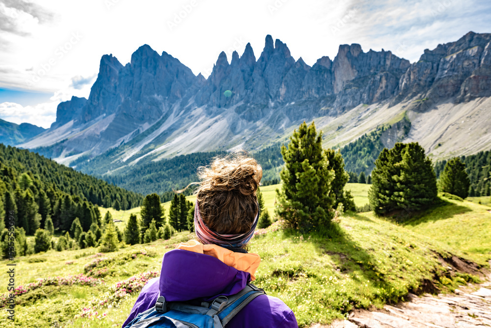 Athletic woman enjoys view from beautiful hike trail at Seceda in the dolomites at noon. Seceda, Saint Ulrich, Dolomites, Belluno, Italy, Europe.