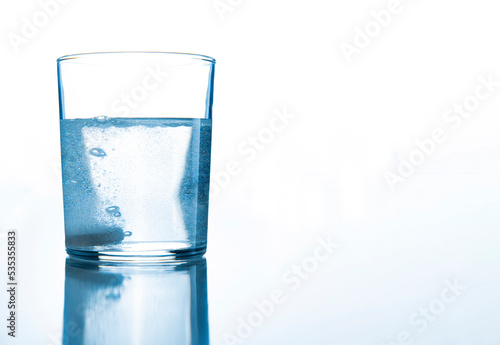 a glass of water on a white background, large space for text on the left © Andrey