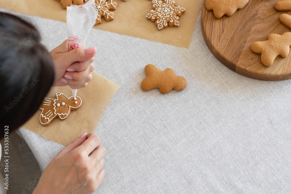 Foto Women's hands decorate sugar icing homemade traditional New Year's cookies snowf
