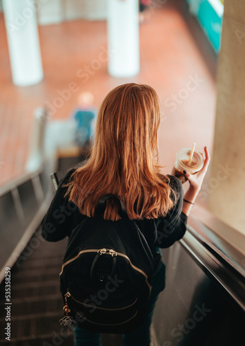woman coffee going down escalators miami Brickell subway 