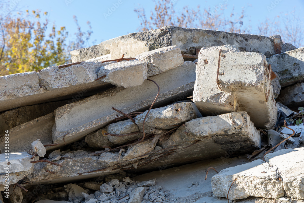 Fragments of a destroyed concrete building. The wreckage of a demolished building. Reinforcing bars and broken concrete. Pile of concrete debris. Construction debris close-up Fragments of a destroyed concrete building. The wreckage of a demolished building. Reinforcing bars and broken concrete. Pile of concrete debris. Construction debris close-up