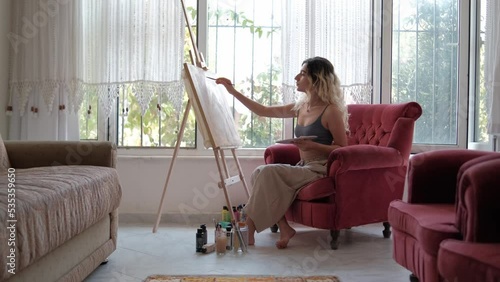 young woman painting oil on canvas, focused artist