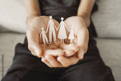 Hands holding paper family cutout, family home,life insurance, adoption foster care, homeless support , mental health, homeschooling education, Autism support, parent day photo