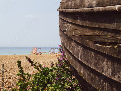 Weathered planks of old wooden boat rotting away in foreground on Brighton Beach photo