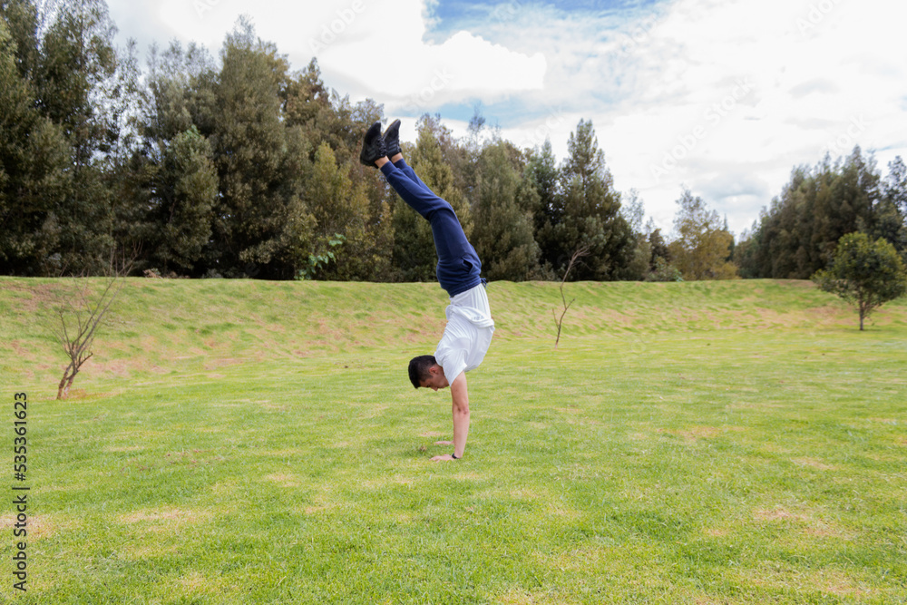 A man handstand in a park on sunny day A man handstand in a park on sunny day