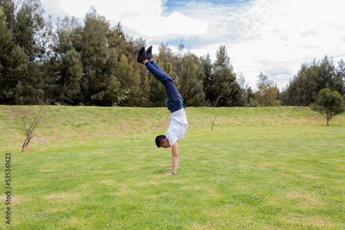 A man handstand in a park on sunny day