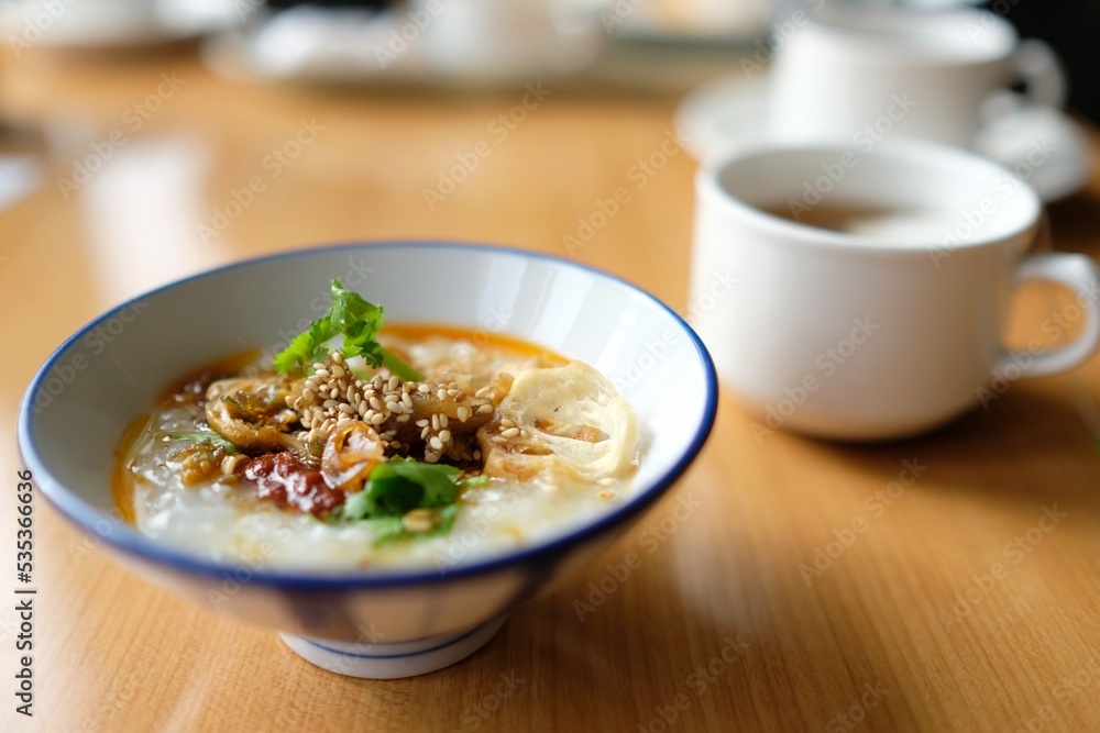 A bowl of Japanese rice porridge with traditional condiments at the breakfast buffet of an airport hotel in Narita, Japan