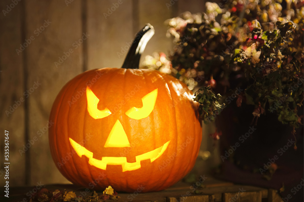 Scary jack o'lantern pumpkin on wooden bench in darkness. Halloween decor Scary jack o'lantern pumpkin on wooden bench in darkness. Halloween decor