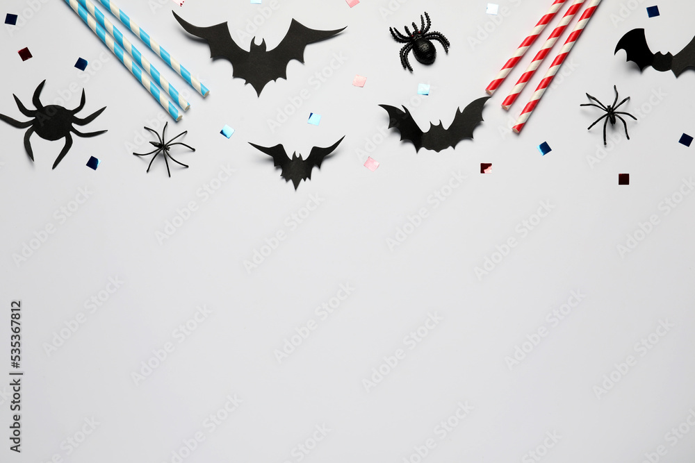Flat lay composition with paper bats, spiders and straws on white background, space for text. Halloween celebration Flat lay composition with paper bats, spiders and straws on white background, space for text. Halloween celebration