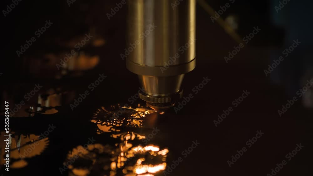 Laser cutting machine making eagle shaped holes in sheet metal with many sparks at factory, plant - close up. Metalworking, industrial, equipment, technology and manufacturing concept Laser cutting machine making eagle shaped holes in sheet metal with many sparks at factory, plant - close up. Metalworking, industrial, equipment, technology and manufacturing concept