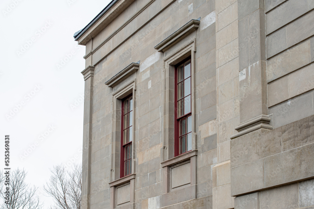 The exterior of a vintage limestone block wall with multiple windows