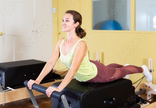 Woman doing pilates exercises lying on pilates workout machines