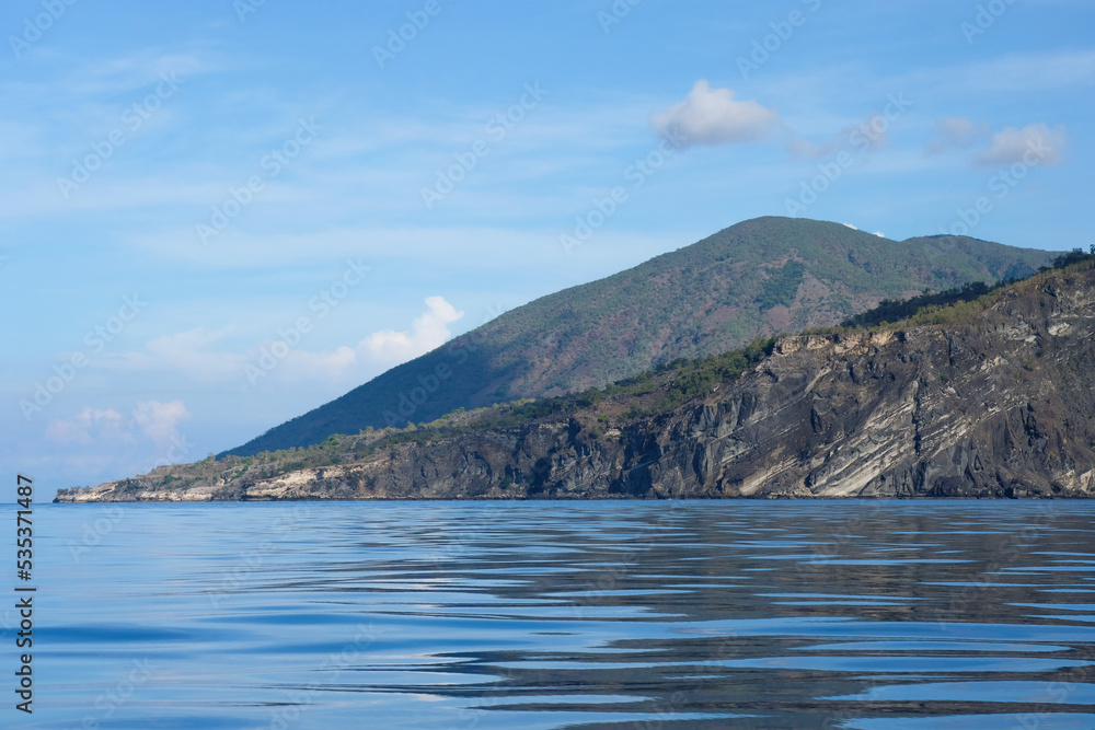 A glimpse of Atauro Island in Timor-Leste, South East Asia, on extinct Wetar segment of the volcanic Inner Banda Arc, rugged, rocky, steep ridges and slopes of remote island in the tropics