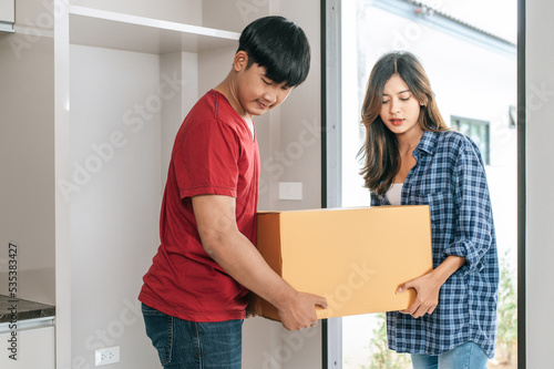 Young couple moving package into new house. © Johnstocker