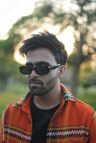 young man wearing jacket walking in park